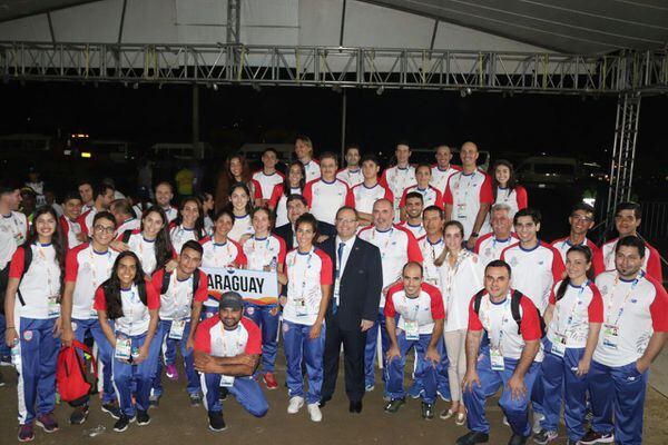 Los atletas paraguayos posan con el titular del COP tras el desfile inaugural